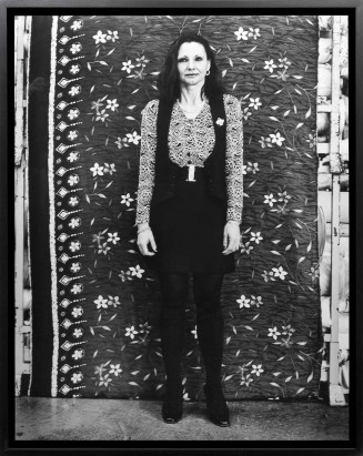 Portrait d'une femme debout devant un fond en tissu 