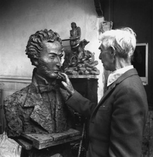 Ossip Zadkine dans son atelier de la rue d'Assas à Paris : il travaille sur un buste du poète russe Alexandre Pouchkine. 1965 © akg-images / Daniel Frasnay