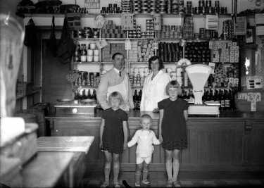 Famille posant dans son magasin, 1920-1930. Photographie noir et blanc de Kazimir Zgorecki © Musée national de l'histoire et des cultures de l'immigration