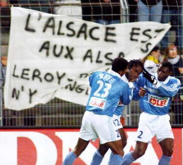 Strasbourg's Guy Mancamba Luyindula (C) is congratulated by team-mates Habib Beye (L) and Pierre Njanka Beaka (R) after scoring his team's 1st goal on December 03, 1999 against Bastia