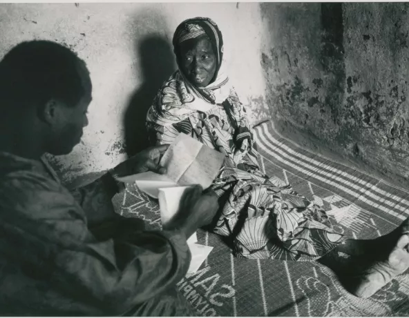 Un immigré malien, de retour de chez lui lit à sa mère, restée au village, une lettre de sa femme. Village de Diouncoulane, région de Kayes, 1994 © Patrick Zachmann/Magnum Photos/Musée national de l’histoire et des cultures de l’immigration