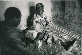 Un immigré malien, de retour de chez lui lit à sa mère, restée au village, une lettre de sa femme. Village de Diouncoulane, région de Kayes, 1994 © Patrick Zachmann/Magnum Photos/Musée national de l’histoire et des cultures de l’immigration