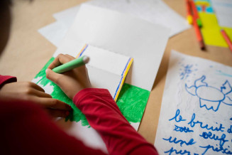 Enfant qui colorie son carnet