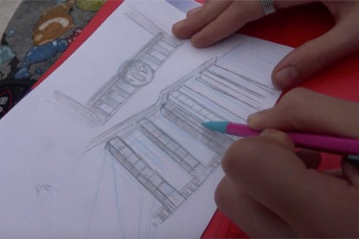 Photo d'une main dessinant le Palais 