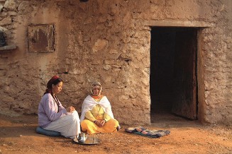 Visuel du film "L'enfant endormi" deux personnes assises devant une maison