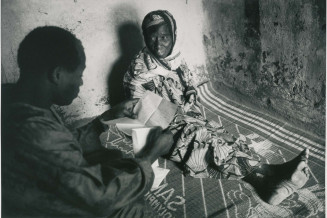 Un immigré malien, de retour de chez lui lit à sa mère, restée au village, une lettre de sa femme. Village de Diouncoulane, région de Kayes, 1994 © Patrick Zachmann/Magnum Photos/Musée national de l’histoire et des cultures de l’immigration