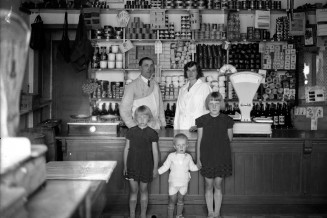 Famille posant dans son magasin, 1920-1930. Photographie noir et blanc de Kazimir Zgorecki © Musée national de l'histoire et des cultures de l'immigration