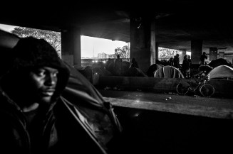 Un réfugié guinéen dans sa tente sous l’échangeur autoroutier de la Chapelle. Paris, France. Mai 2019. Photographie Michael Bunel