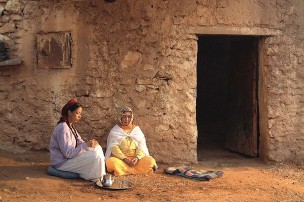 Visuel du film "L'enfant endormi" deux personnes assises devant une maison