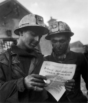 Des mineurs lisent un journal syndical édité en polonais, en 1950. En titre : « L’unité est la condition essentielle de notre victoire » © Eyedea/Willy RONIS/Rapho