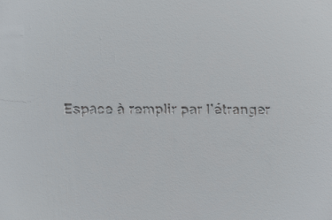 Latifa Echakhch, Hospitalité, 2006, inscription en creux dans le mur, édition 3/3. Collection du Musée national de l'histoire de l'immigration. 2012.34.1