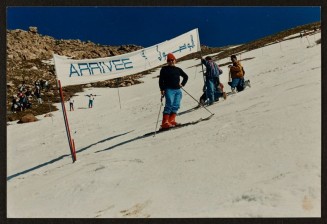 Saïd Abtout est à ski dans une station en Algérie devant un panneau en français et en Algérien signalant "Arrivée".