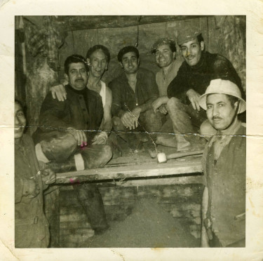 Photographie de 7 hommes en habit de travail, sur un chantier