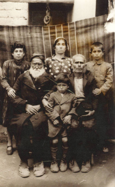 Ohannès Mampreyan enfant  (au centre) et sa famille : son oncle (barbe blanche) et sa sœur (debout au centre) (Syrie, 1920) © Musée national de l'histoire et des cultures de l'immigration